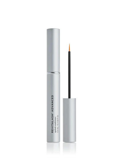 A bottle of RevitaLash Advanced eyelash conditioning serum with the brand name displayed prominently on the packaging. The product is shown with the cap off, revealing the applicator wand.